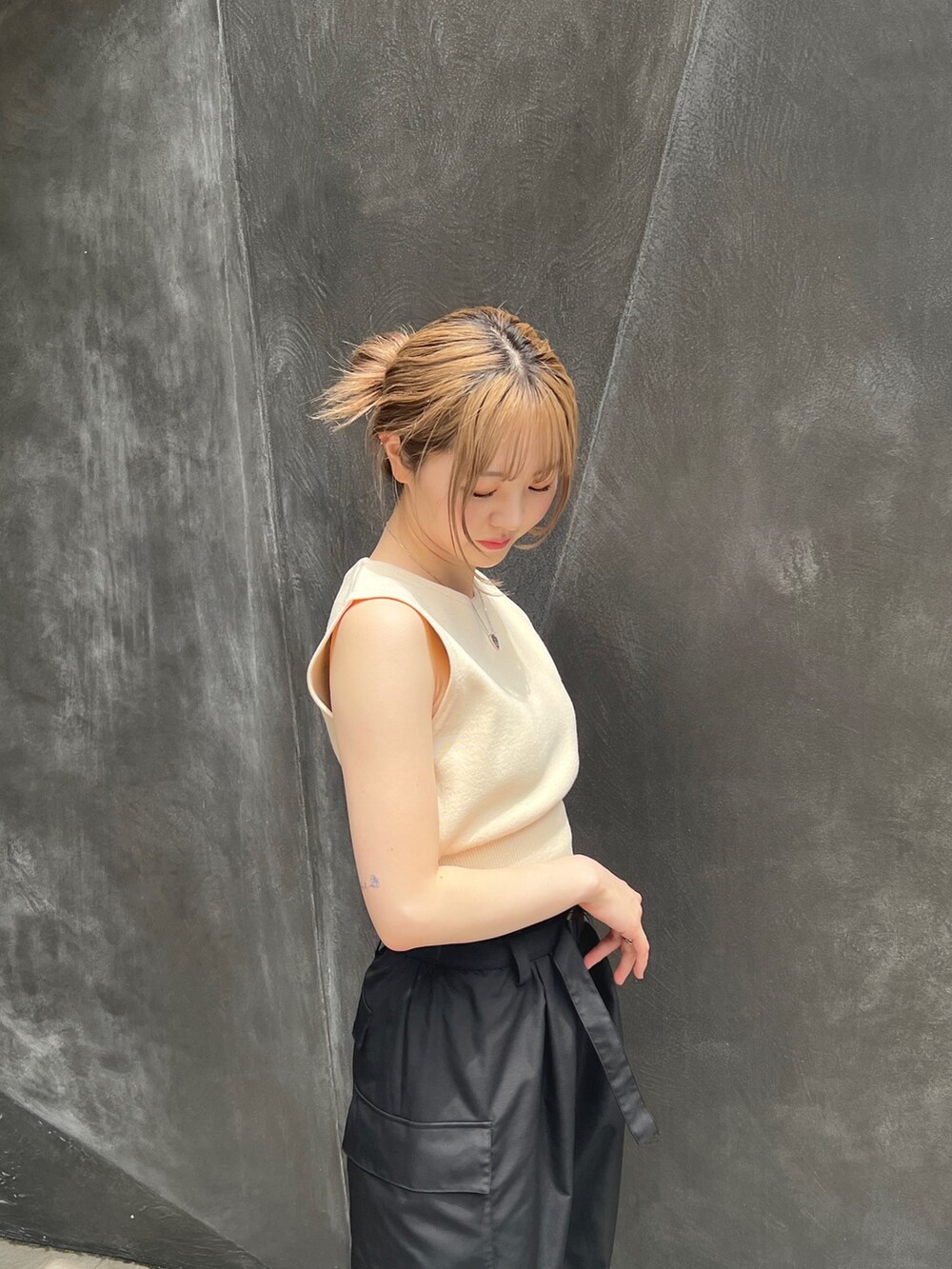 ブラック系のカーゴパンツ、ホワイト系のベストを着用したレディースの夏コーディネートの3枚目の写真