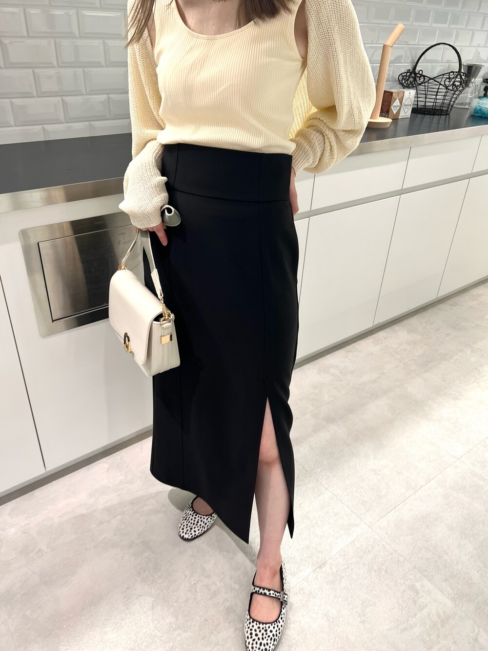 ホワイト系のカーディガン/ボレロ、ブラック系のスカート、ホワイト系のショルダーバッグを着用したレディースの夏コーディネートの3枚目の写真