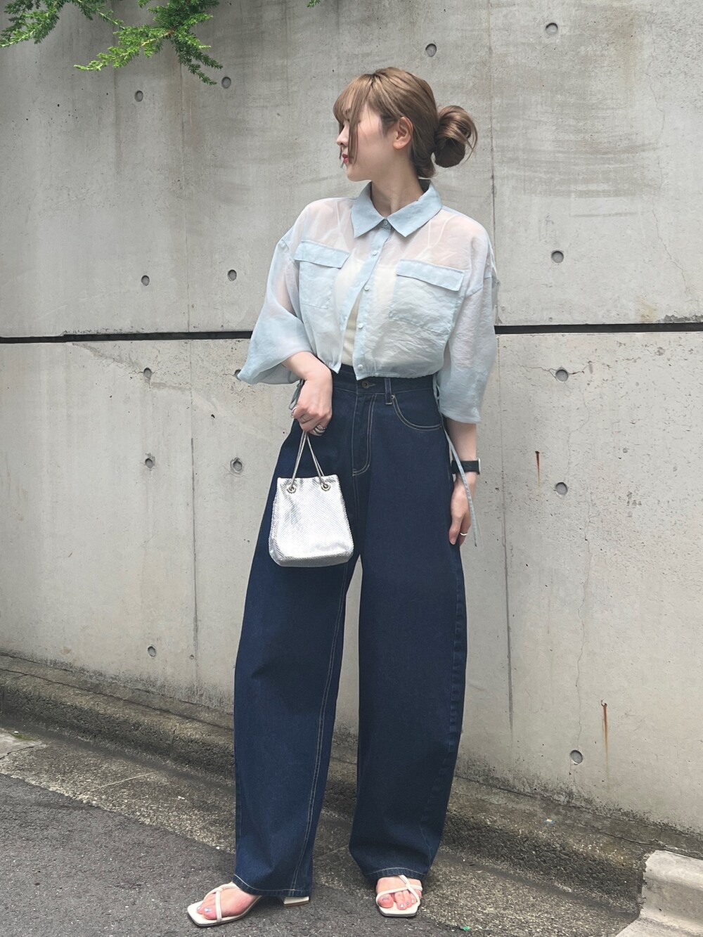 ブルー系のシャツ/ブラウス、ブルー系のデニムパンツ、シルバー系のハンドバッグを着用したレディースの夏コーディネートの2枚目の写真