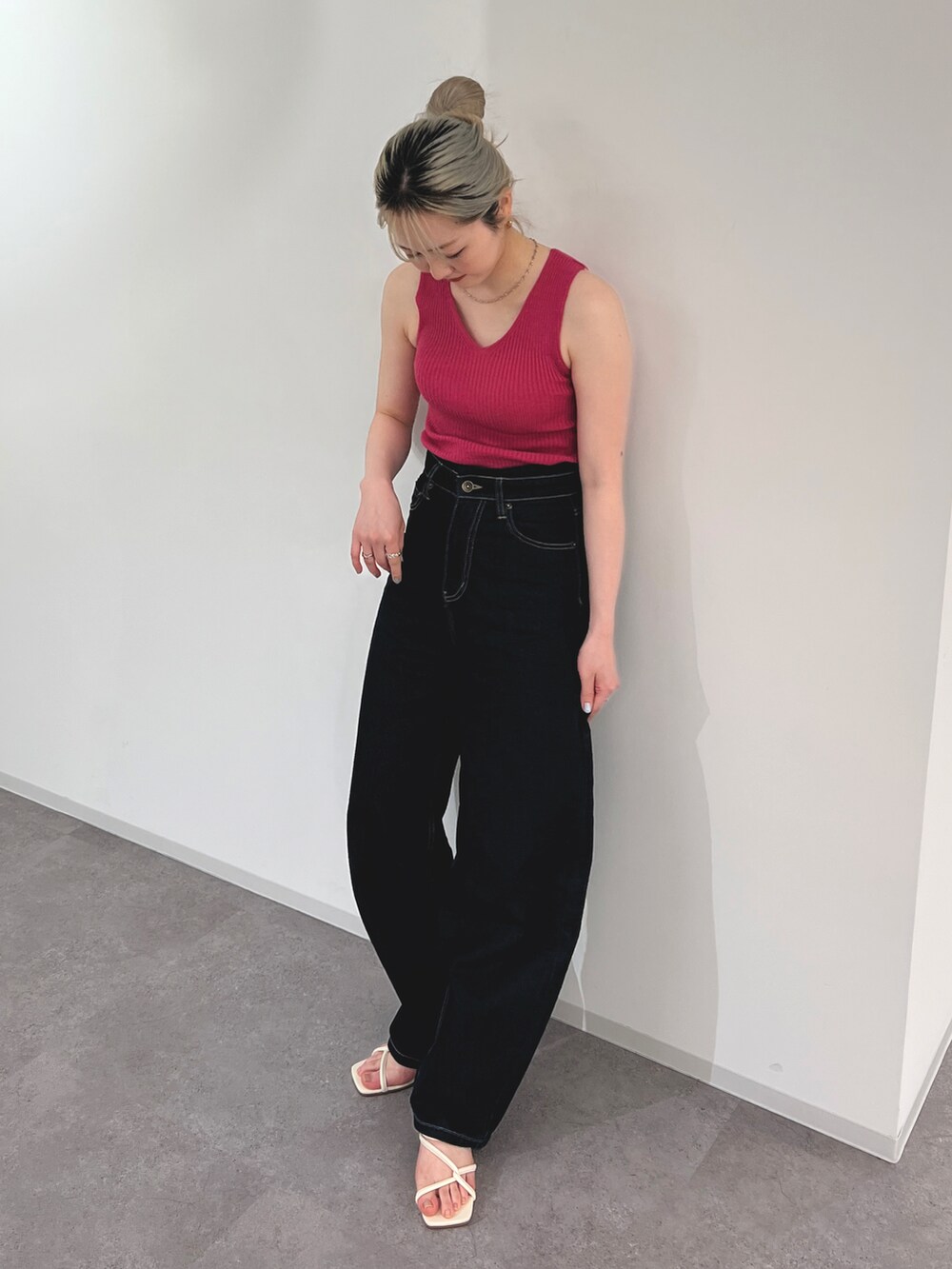 ブルー系のデニムパンツ、ピンク系のタンクトップ、ホワイト系のサンダルを着用したレディースの春コーディネートの3枚目の写真