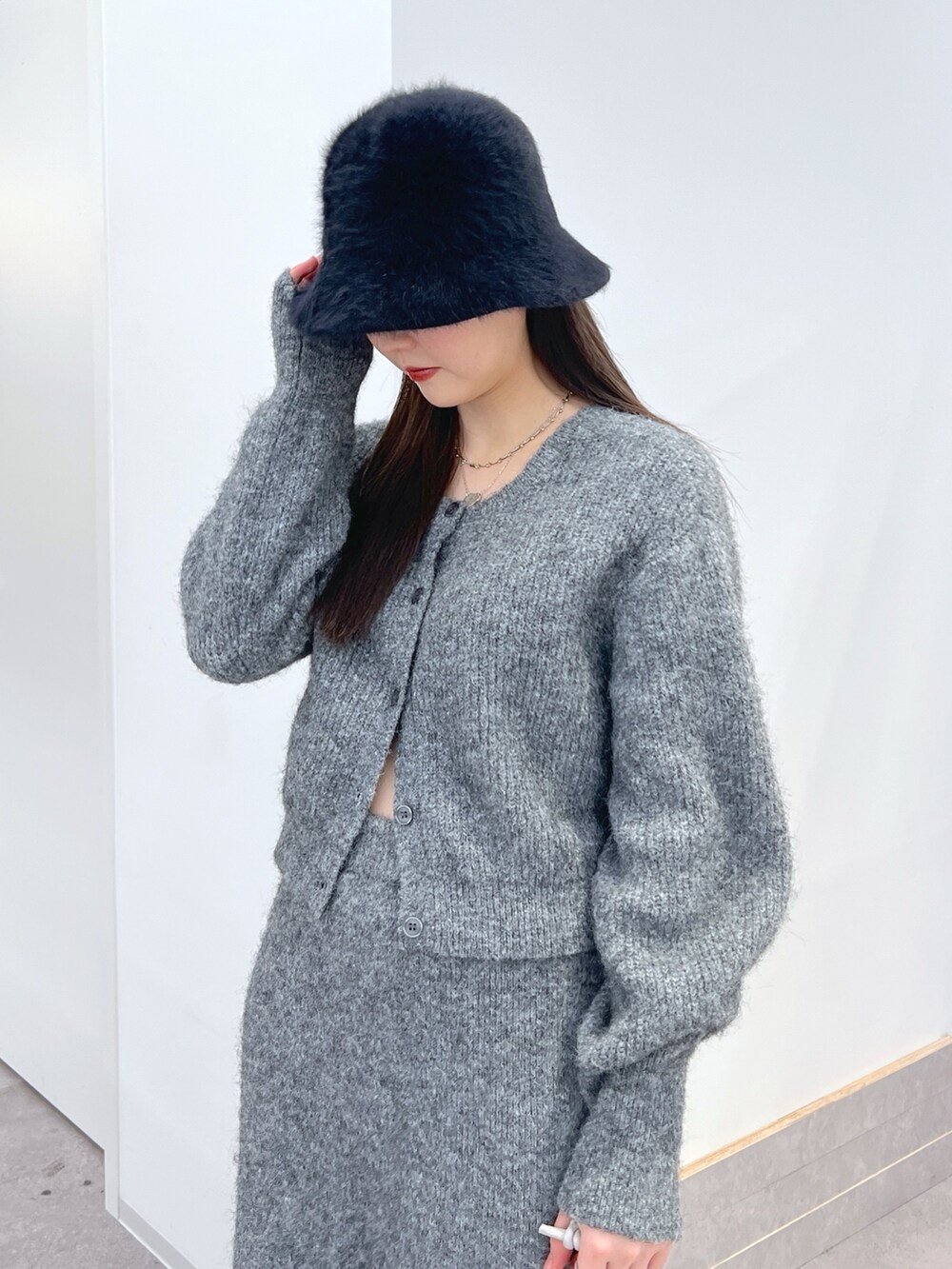 グレー系のニット/セーター、グレー系のスカートを着用したレディースの冬コーディネートの2枚目の写真