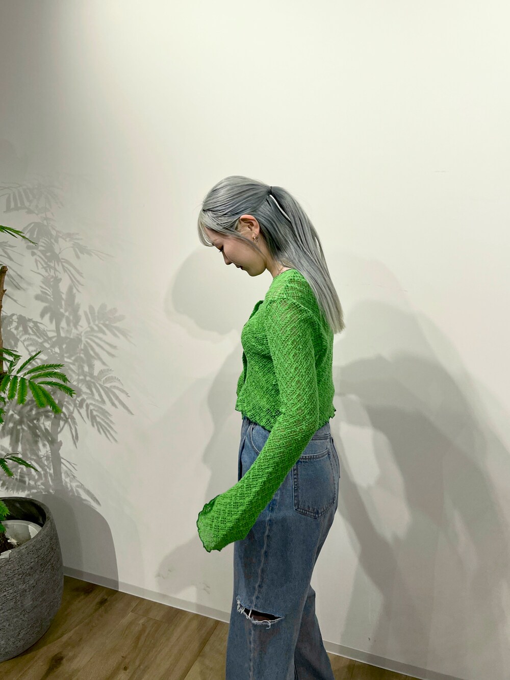 グリーン系のカーディガン/ボレロ、ブルー系のデニムパンツ、ホワイト系のサンダルを着用したレディースの春コーディネートの4枚目の写真