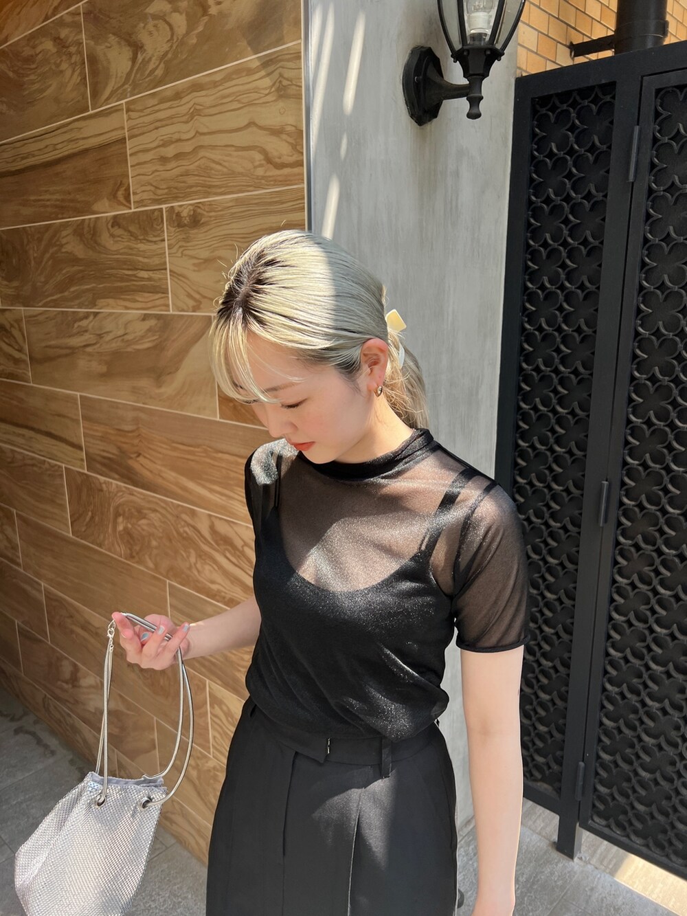 ブラック系のTシャツ/カットソー、ブラック系のスカート、シルバー系のハンドバッグを着用したレディースの夏コーディネートの3枚目の写真