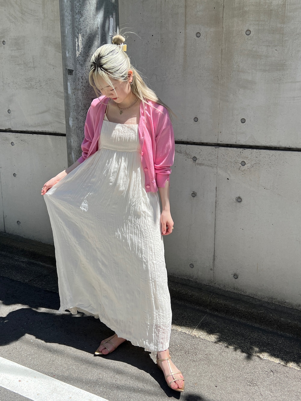 ホワイト系のワンピース、ピンク系のカーディガン/ボレロ、ゴールド系のサンダルを着用したレディースの春コーディネートの2枚目の写真