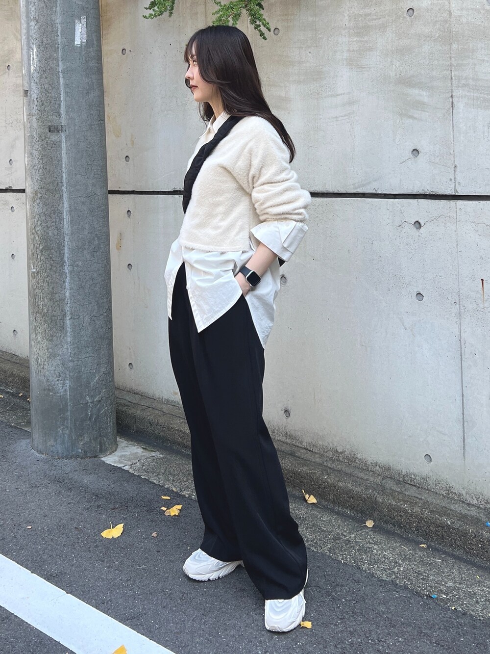 ホワイト系のニット/セーター、ブラック系のスラックス、ホワイト系のスニーカーを着用したレディースの秋コーディネートの2枚目の写真