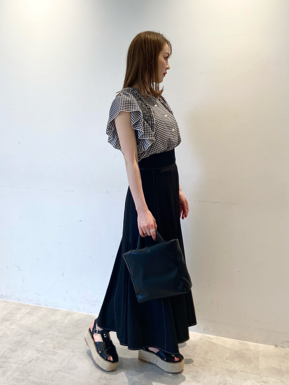ブラック系のシャツ/ブラウス、ブラック系のスカート、ブラック系のショルダーバッグを着用したレディースの夏コーディネートの3枚目の写真