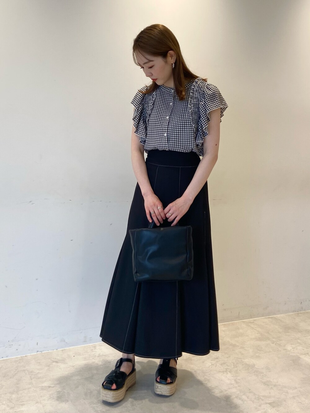 ブラック系のシャツ/ブラウス、ブラック系のスカート、ブラック系のショルダーバッグを着用したレディースの夏コーディネートの2枚目の写真