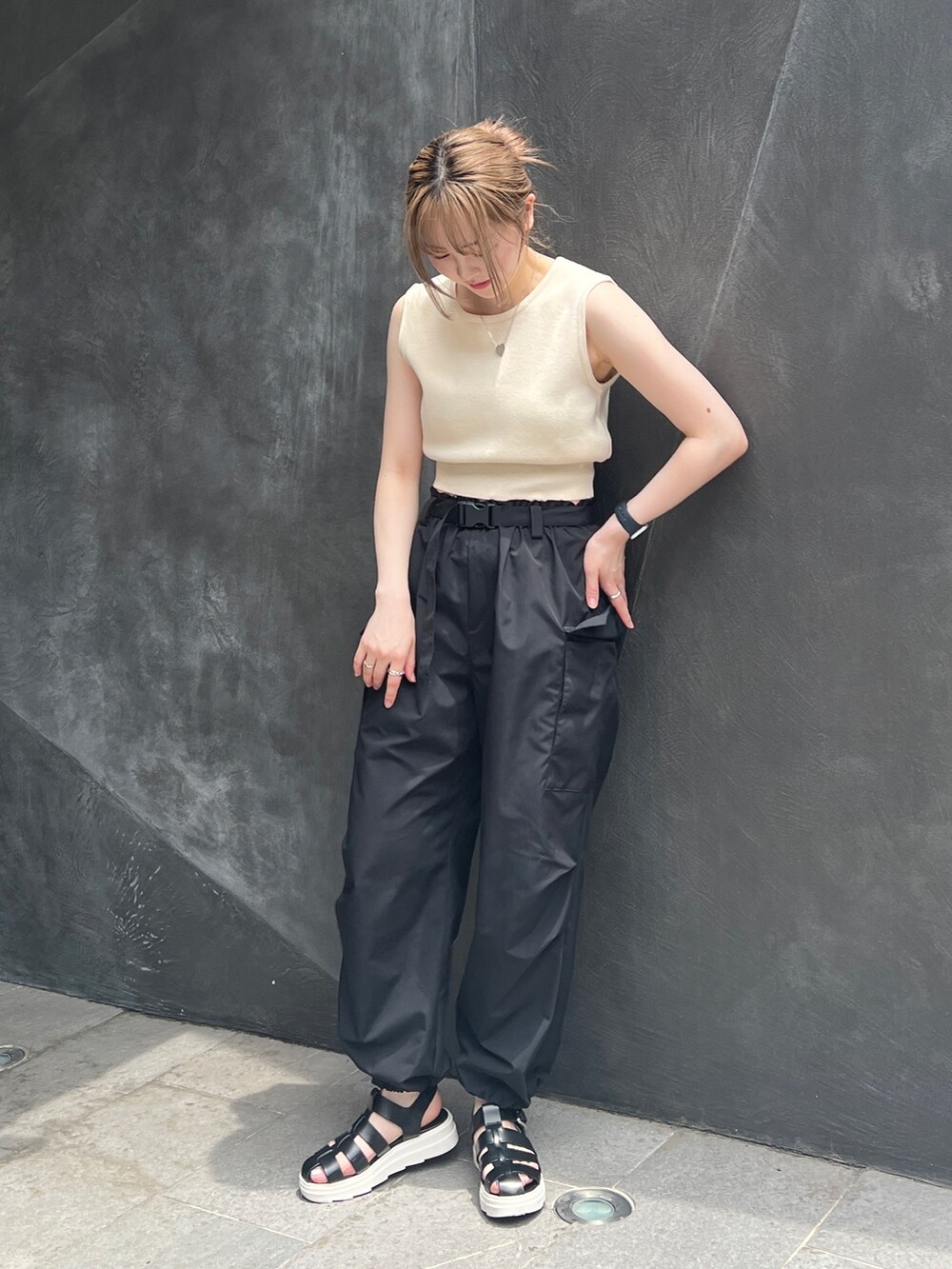 ブラック系のカーゴパンツ、ホワイト系のベストを着用したレディースの夏コーディネートの2枚目の写真