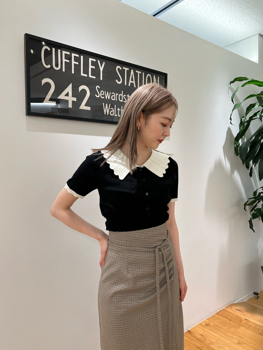 ブラック系のニット/セーター、ベージュ系のスカート、ホワイト系のその他シューズを着用したレディースの夏コーディネートの2枚目の写真