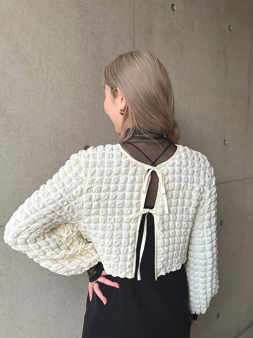 ホワイト系のシャツ/ブラウス、ブラック系のジャンパースカート、ブラック系のTシャツ/カットソーを着用したレディースの冬コーディネートの4枚目の写真