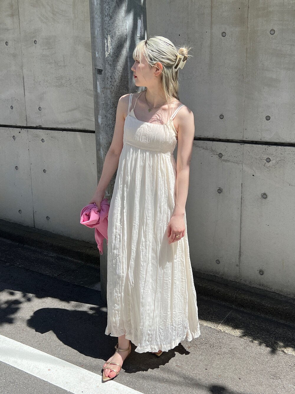 ホワイト系のワンピース、ピンク系のカーディガン/ボレロ、ゴールド系のサンダルを着用したレディースの春コーディネートの3枚目の写真