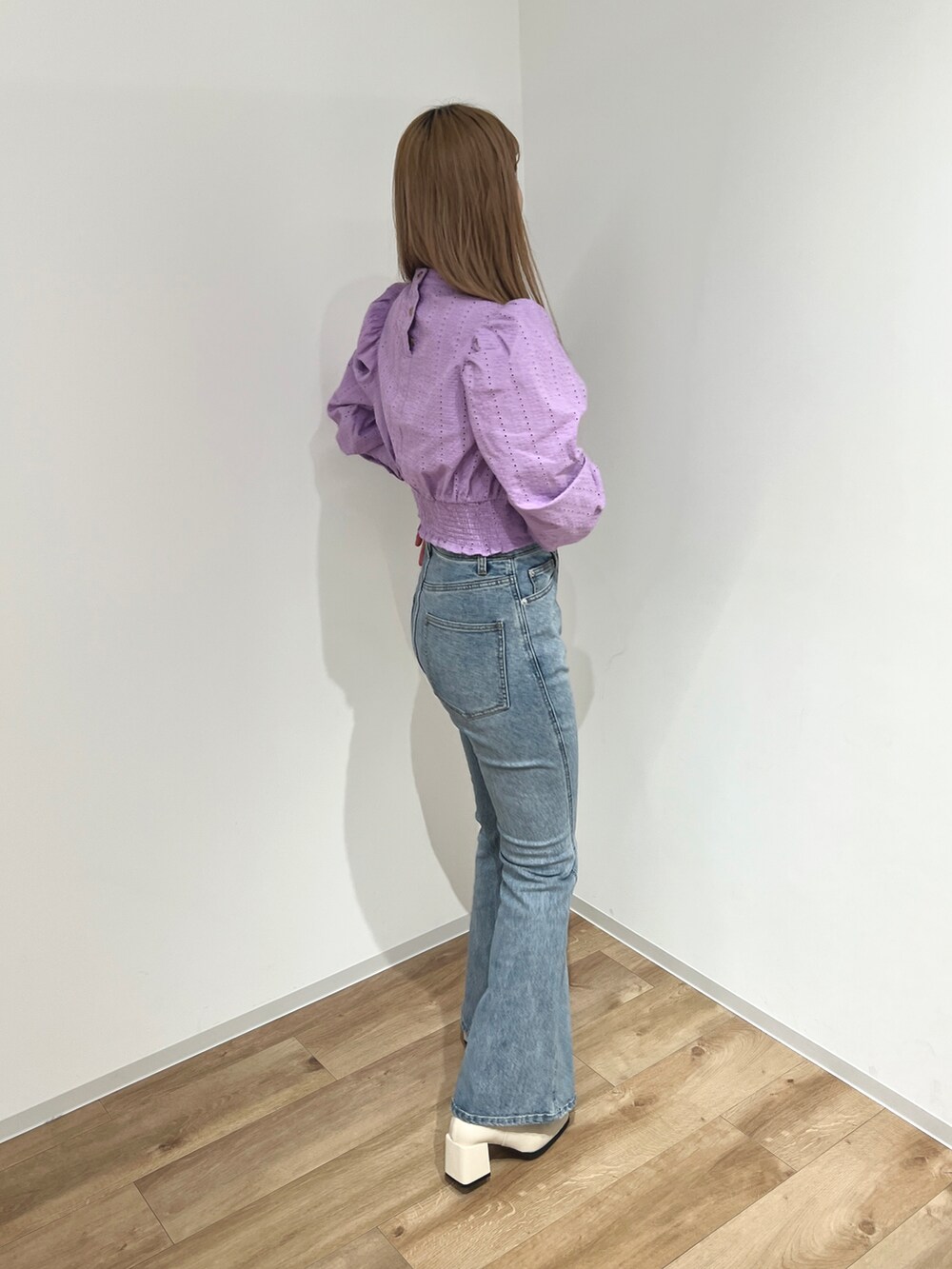 パープル系のシャツ/ブラウス、ブルー系のデニムパンツ、ホワイト系のブーツを着用したレディースの冬コーディネートの2枚目の写真