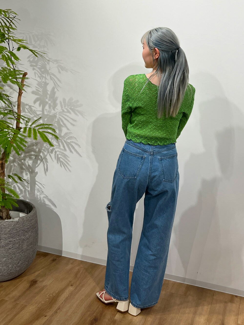 グリーン系のカーディガン/ボレロ、ブルー系のデニムパンツ、ホワイト系のサンダルを着用したレディースの春コーディネートの2枚目の写真