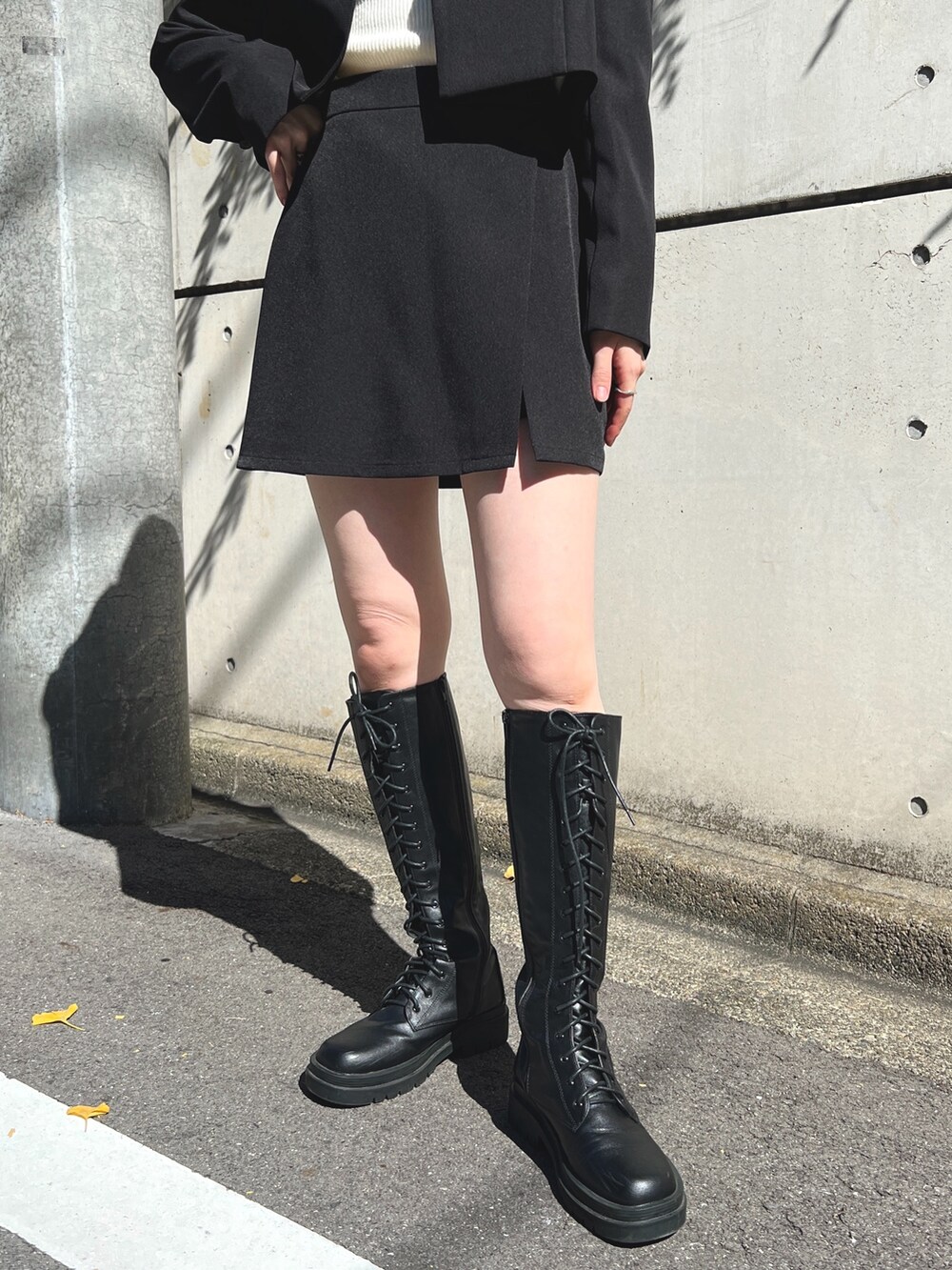 ブラック系のテーラードジャケット、ホワイト系のニット/セーター、ブラック系のその他パンツを着用したレディースの秋コーディネートの3枚目の写真