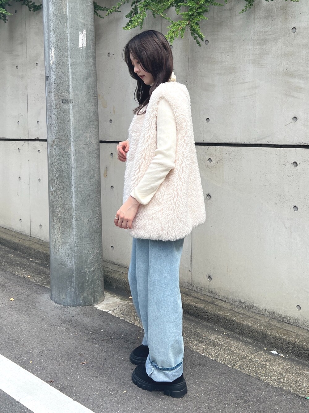 ホワイト系のニット/セーター、ホワイト系のベスト、ブルー系のデニムパンツを着用したレディースの秋コーディネートの2枚目の写真