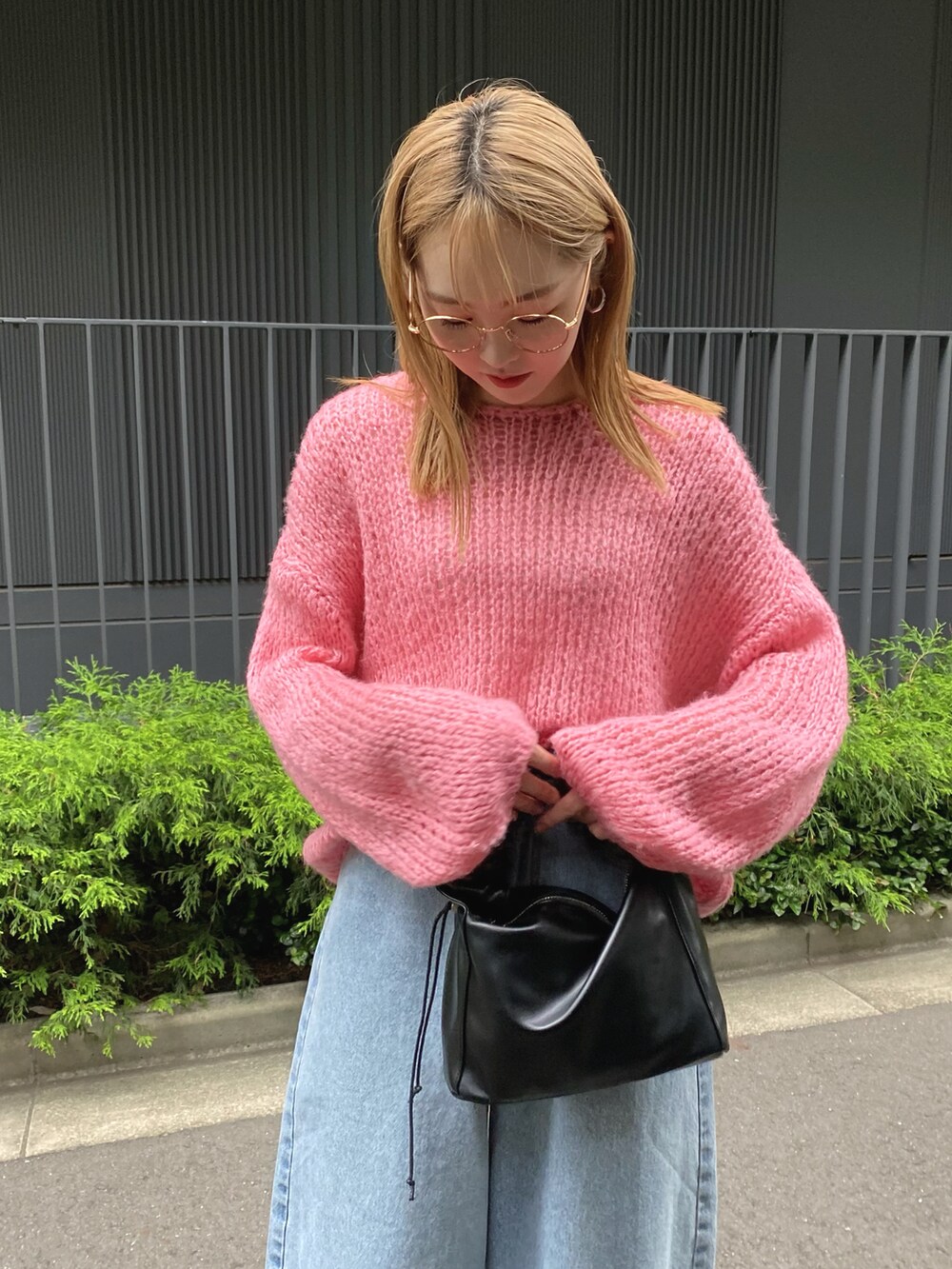 ピンク系のニット/セーター、ブルー系のデニムパンツを着用したレディースの夏コーディネートの2枚目の写真