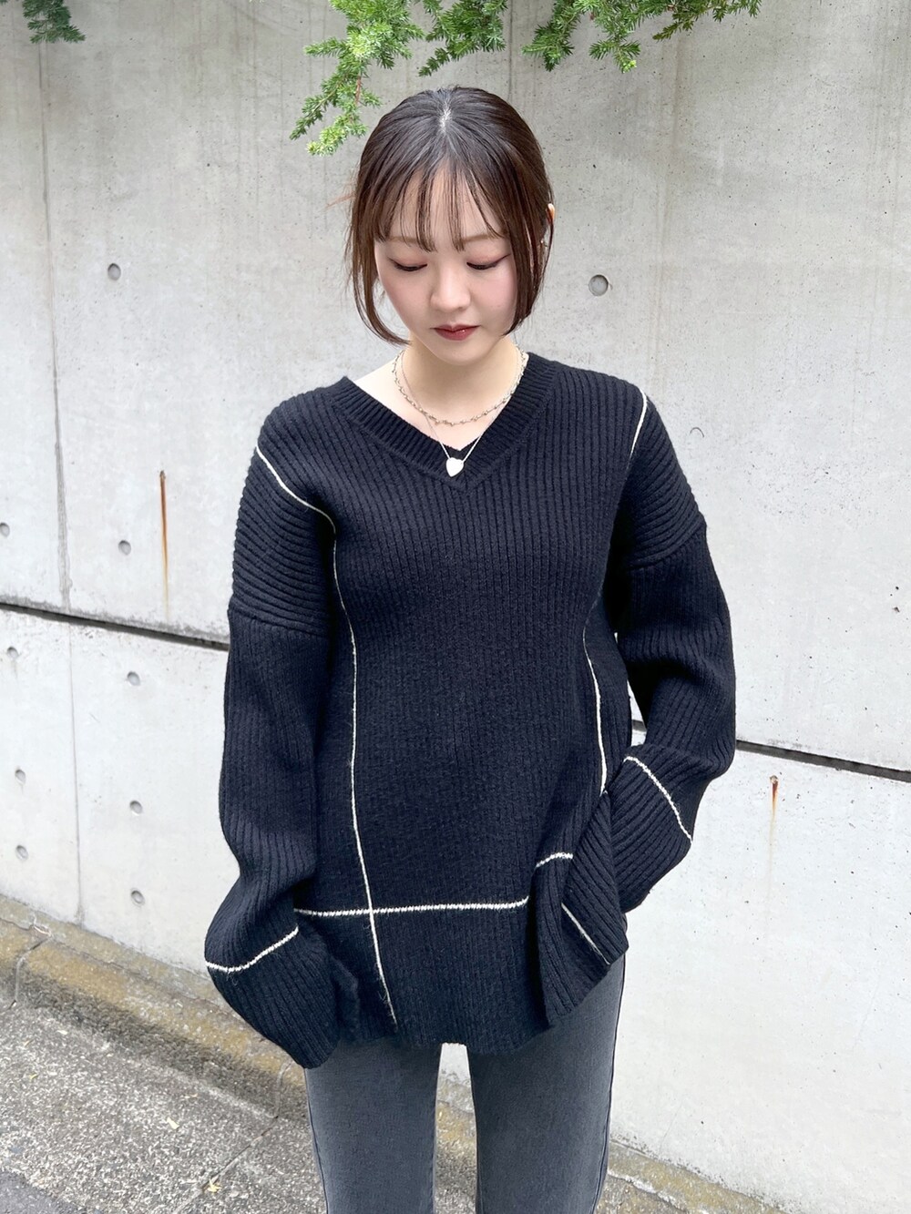 ブラック系のニット/セーター、ブラック系のデニムパンツを着用したレディースの秋コーディネートの2枚目の写真