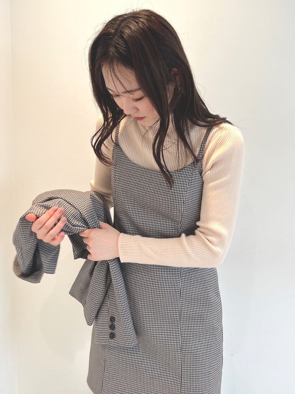 ベージュ系のテーラードジャケット、ベージュ系のワンピース、ホワイト系のニット/セーターを着用したレディースの秋コーディネートの3枚目の写真