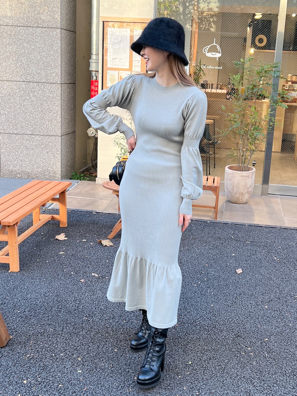 グリーン系のワンピース、ブラック系のショルダーバッグ、ブラック系のハットを着用したレディースの冬コーディネートの2枚目の写真