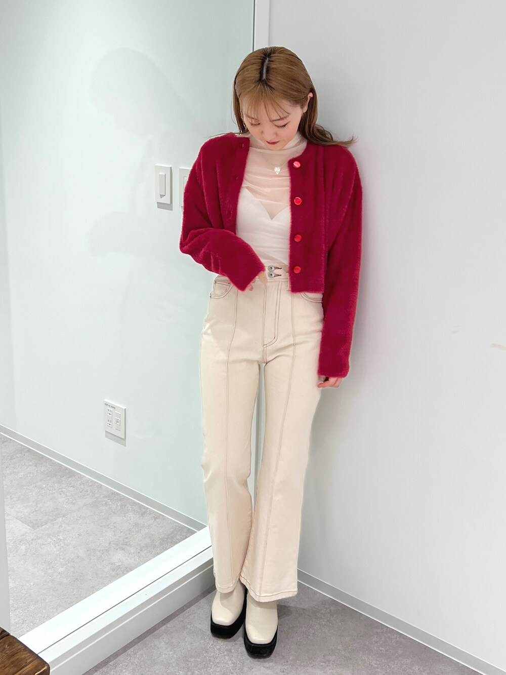 ピンク系のニット/セーター、ホワイト系のデニムパンツ、ホワイト系のブーツを着用したレディースの冬コーディネートの2枚目の写真