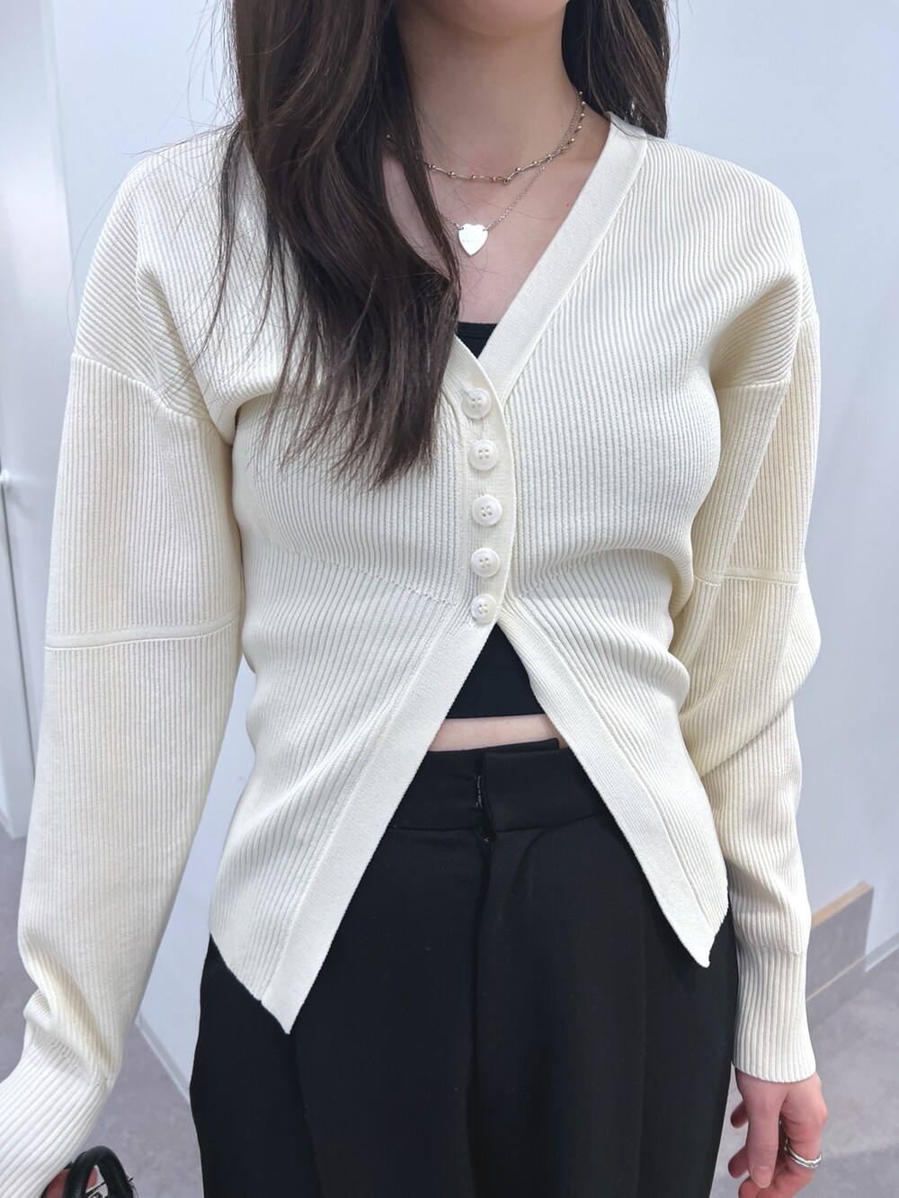 ホワイト系のカーディガン/ボレロ、ブラック系のスラックス、ブラック系のショルダーバッグを着用したレディースの冬コーディネートの3枚目の写真