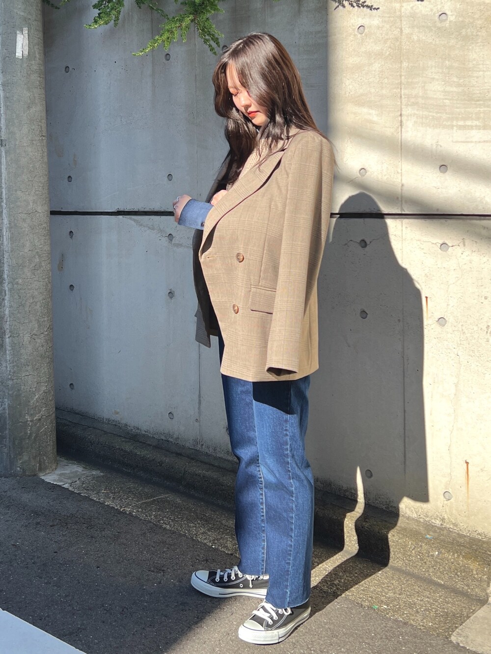 ベージュ系のテーラードジャケット、ブルー系のシャツ/ブラウス、ブルー系のデニムパンツを着用したレディースの秋コーディネートの2枚目の写真