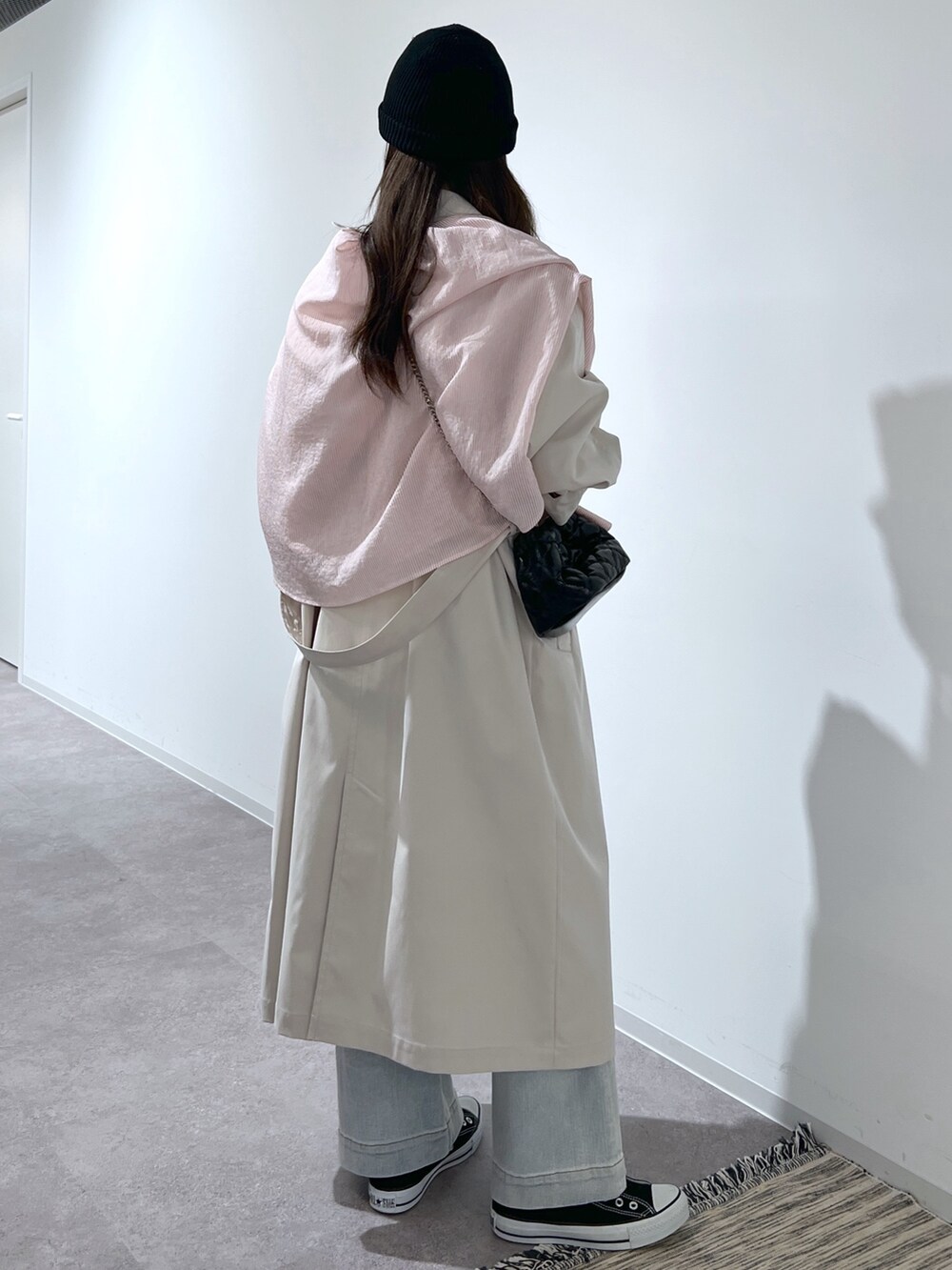 ブルー系のデニムパンツ、ブラック系のショルダーバッグ、ピンク系のシャツ/ブラウスを着用したレディースの春コーディネートの2枚目の写真