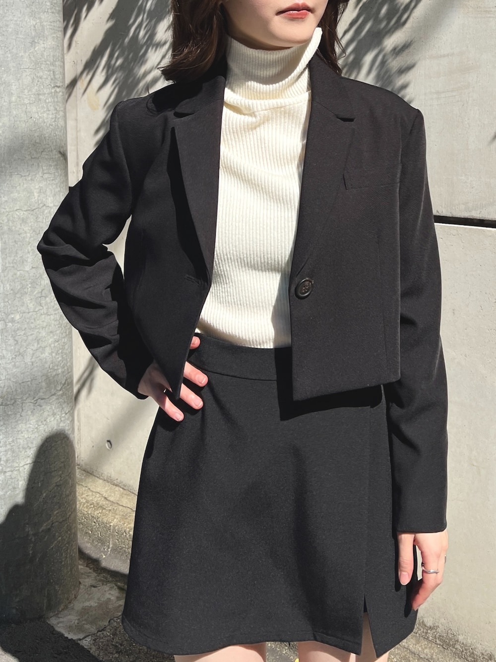 ブラック系のテーラードジャケット、ホワイト系のニット/セーター、ブラック系のその他パンツを着用したレディースの秋コーディネートの2枚目の写真
