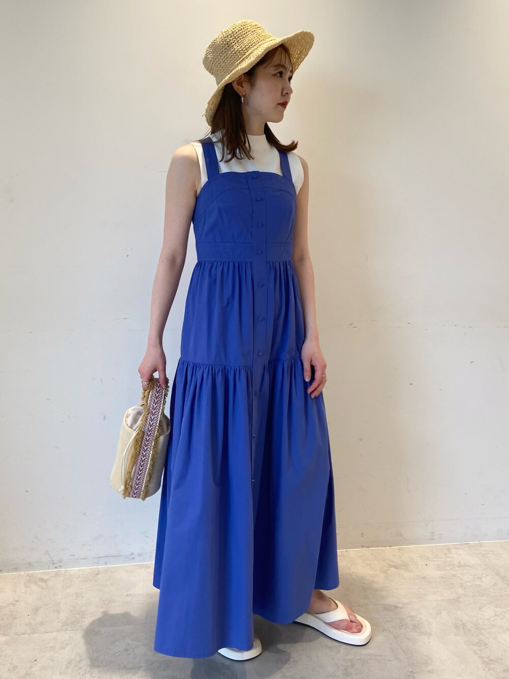 ブルー系のワンピース、ホワイト系のサンダル、ベージュ系のハットを着用したレディースの夏コーディネートの2枚目の写真