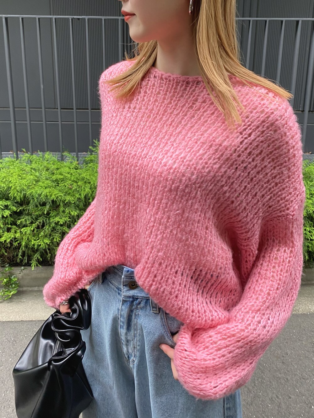 ピンク系のニット/セーター、ブルー系のデニムパンツを着用したレディースの夏コーディネートの3枚目の写真