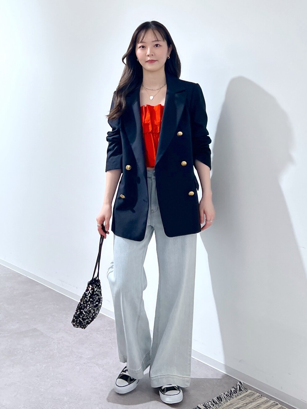 ブルー系のテーラードジャケット、ブルー系のデニムパンツ、ブラック系のハンドバッグを着用したレディースの春コーディネートの2枚目の写真
