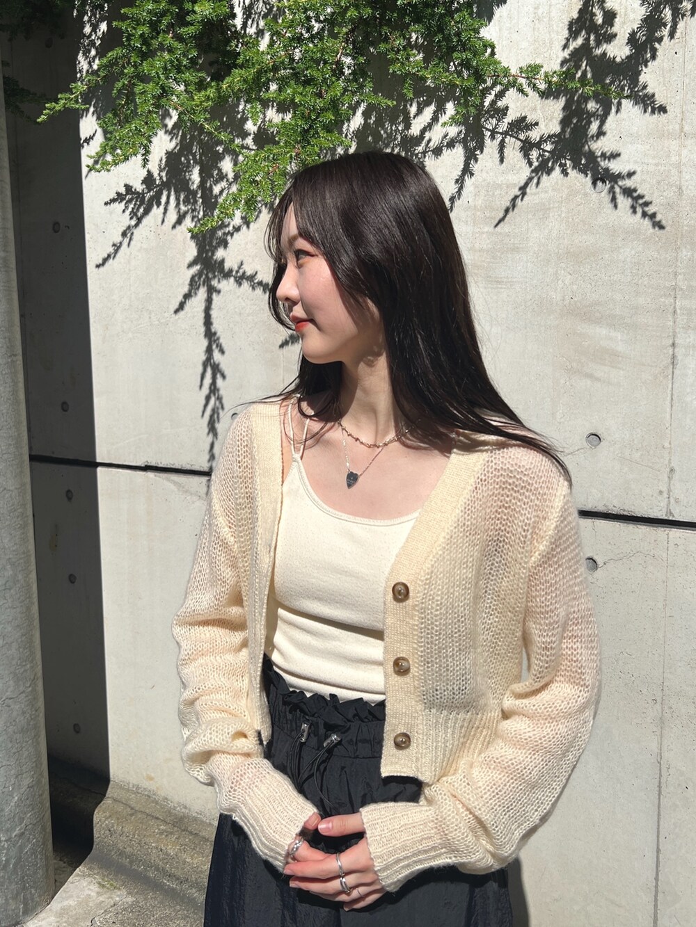 ホワイト系のカーディガン/ボレロ、ブラック系のスカートを着用したレディースの秋コーディネートの3枚目の写真