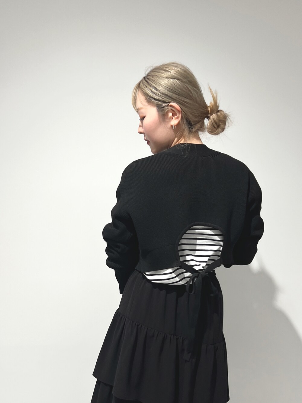 ブラック系のTシャツ/カットソー、ブラック系のカーディガン/ボレロ、ブラック系のスカートを着用したレディースの冬コーディネートの4枚目の写真