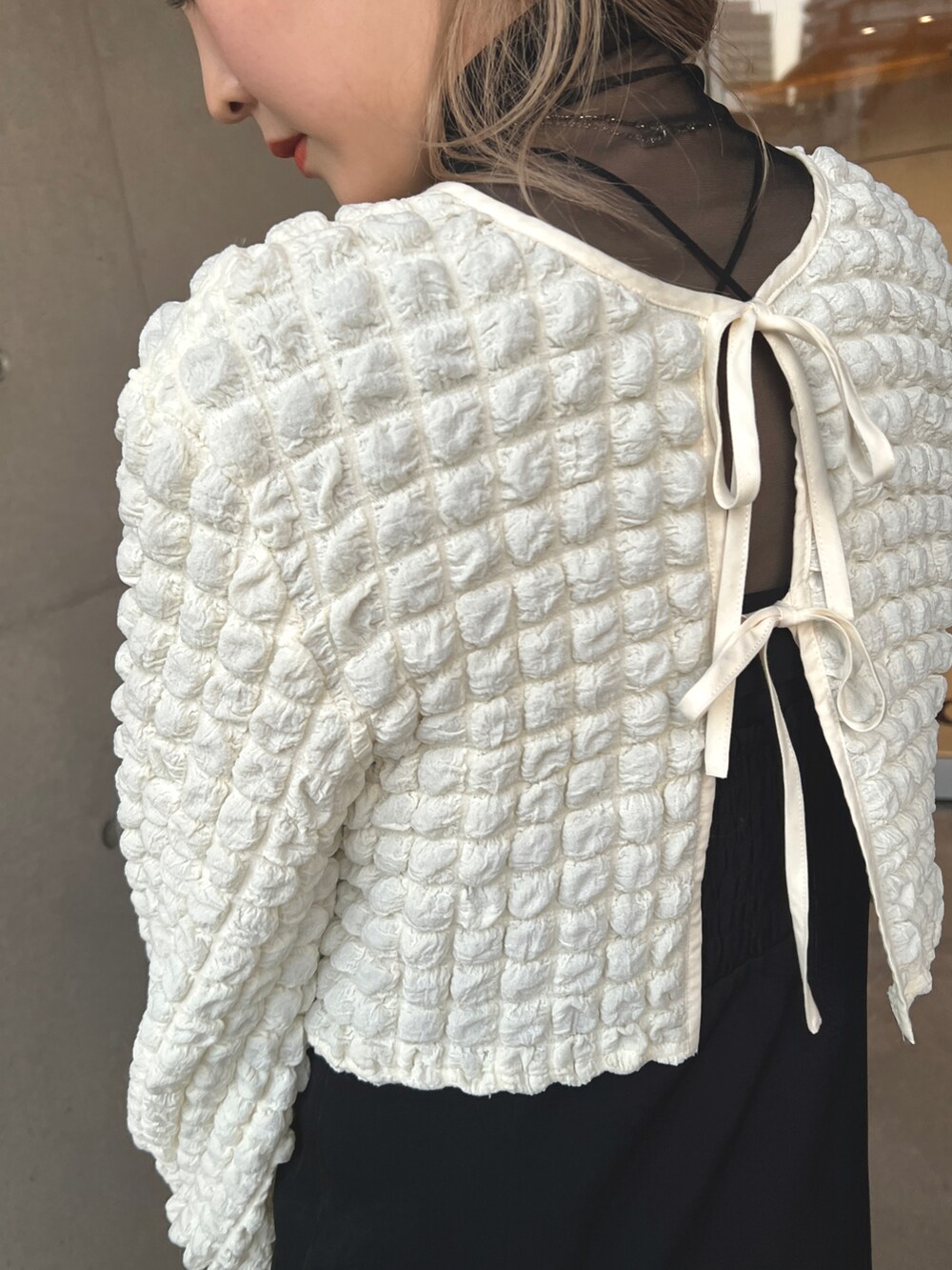 ホワイト系のシャツ/ブラウス、ブラック系のジャンパースカート、ブラック系のTシャツ/カットソーを着用したレディースの冬コーディネートの5枚目の写真