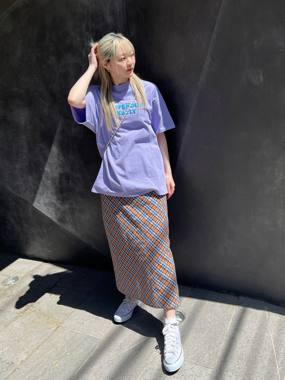 パープル系のTシャツ/カットソー、オレンジ系のスカートを着用したレディースの春コーディネートの2枚目の写真