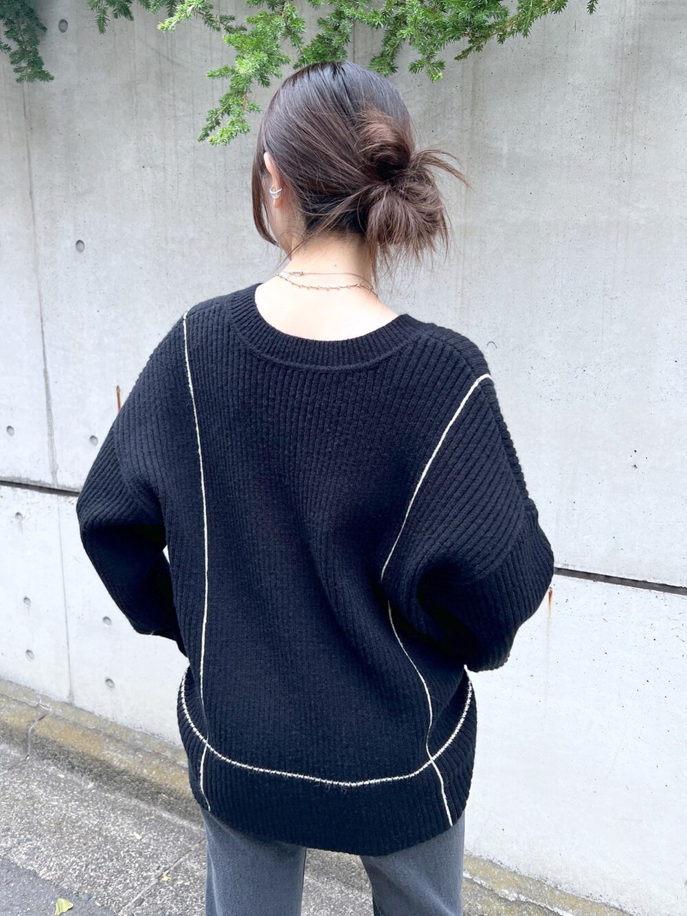 ブラック系のニット/セーター、ブラック系のデニムパンツを着用したレディースの秋コーディネートの3枚目の写真