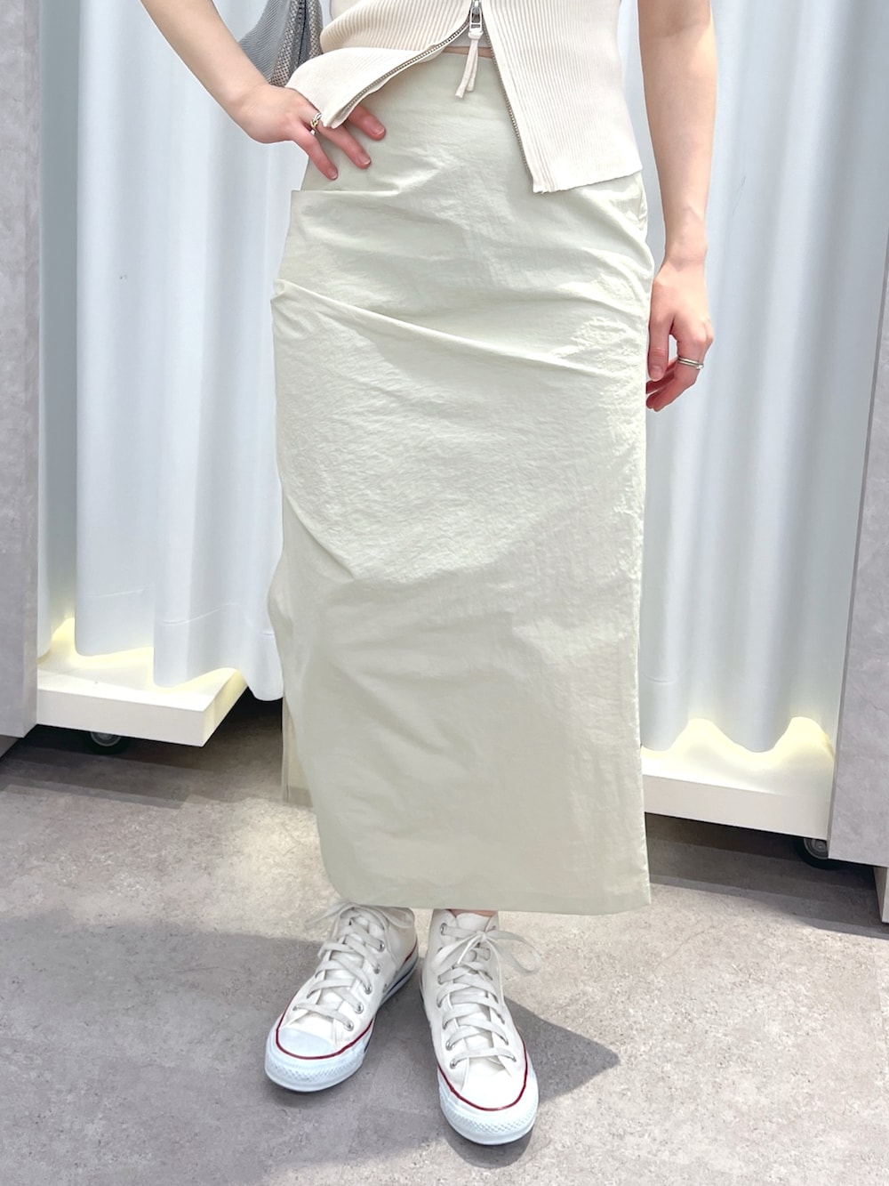 ホワイト系のニット/セーター、ベージュ系のスカート、シルバー系のショルダーバッグを着用したレディースの春コーディネートの3枚目の写真