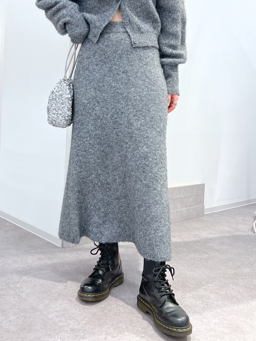 グレー系のニット/セーター、グレー系のスカートを着用したレディースの冬コーディネートの3枚目の写真