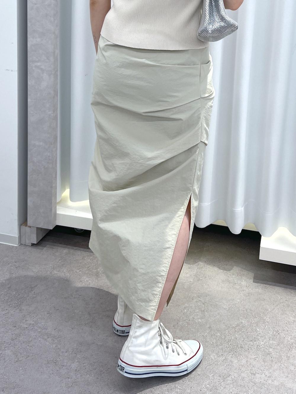 ホワイト系のニット/セーター、ベージュ系のスカート、シルバー系のショルダーバッグを着用したレディースの春コーディネートの4枚目の写真