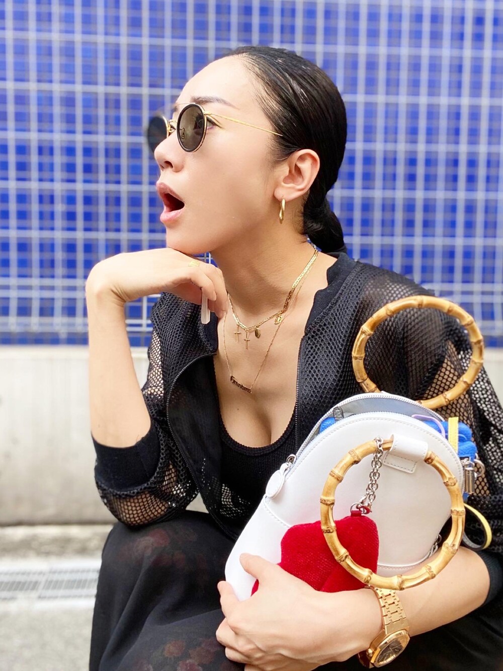 ホワイト系のバッグ、ブラック系のブルゾン、ブラック系のタンクトップを着用したレディースの夏コーディネートの5枚目の写真