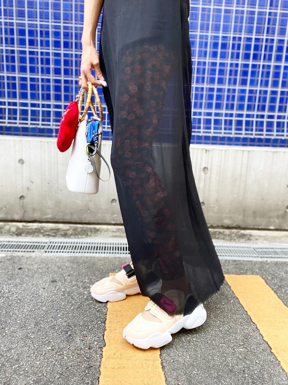 ホワイト系のバッグ、ブラック系のブルゾン、ブラック系のタンクトップを着用したレディースの夏コーディネートの3枚目の写真