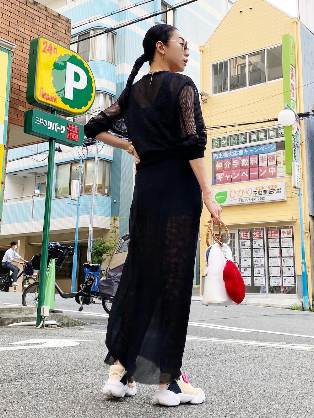 ホワイト系のバッグ、ブラック系のブルゾン、ブラック系のタンクトップを着用したレディースの夏コーディネートの2枚目の写真