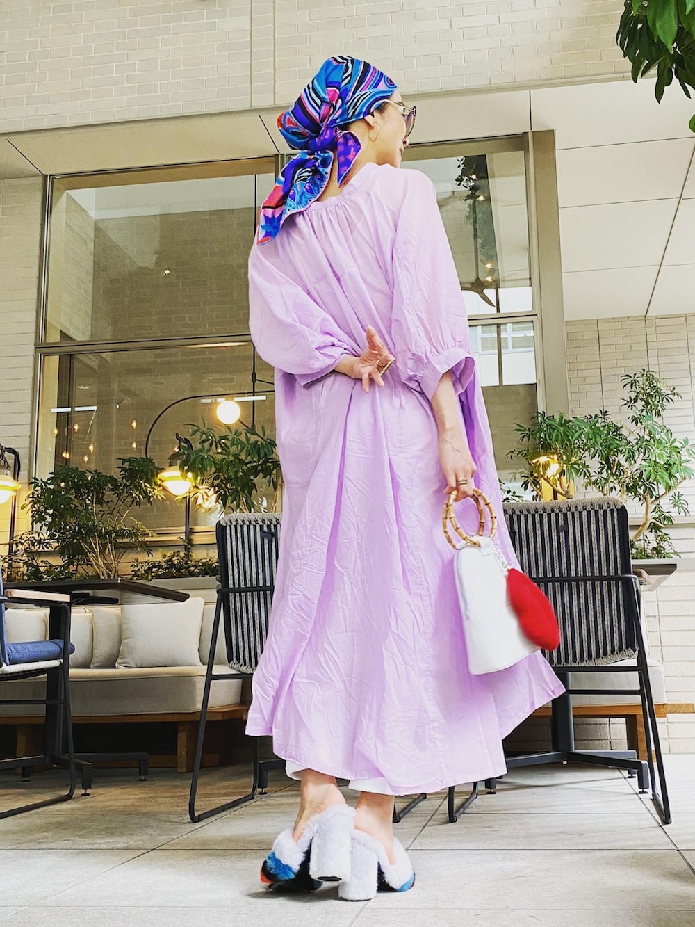 パープル系のシャツワンピース、ホワイト系のバッグ、ホワイト系のパンツを着用したレディースの秋コーディネートの2枚目の写真