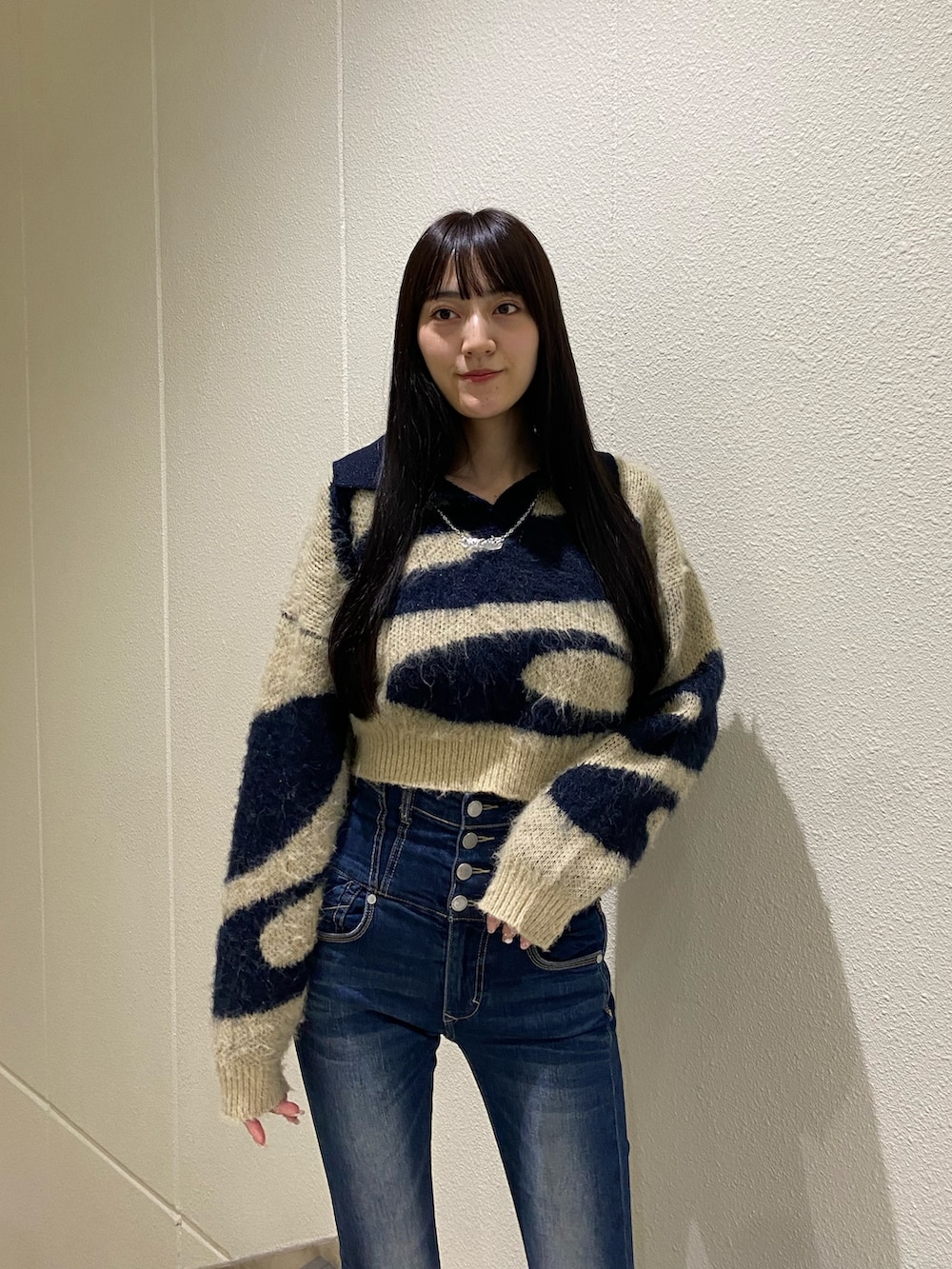 ブルー系のデニムパンツ、ブルー系のニット/セーター、ブラック系のブーツを着用したレディースの秋コーディネートの4枚目の写真