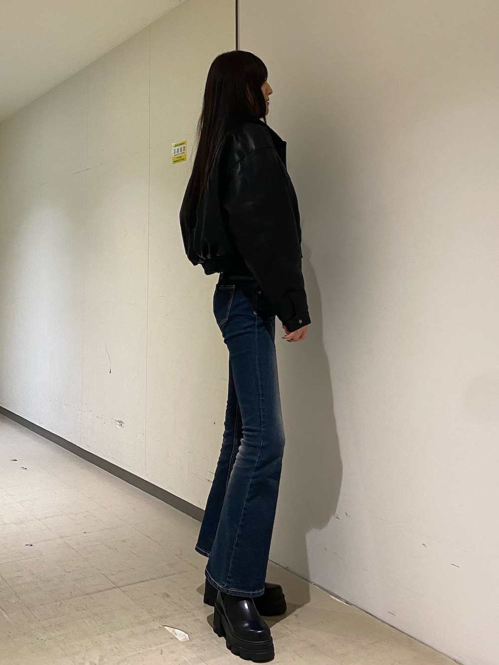 ブルー系のデニムパンツ、ホワイト系のニット/セーター、ブラック系のブルゾンを着用したレディースの秋コーディネートの2枚目の写真