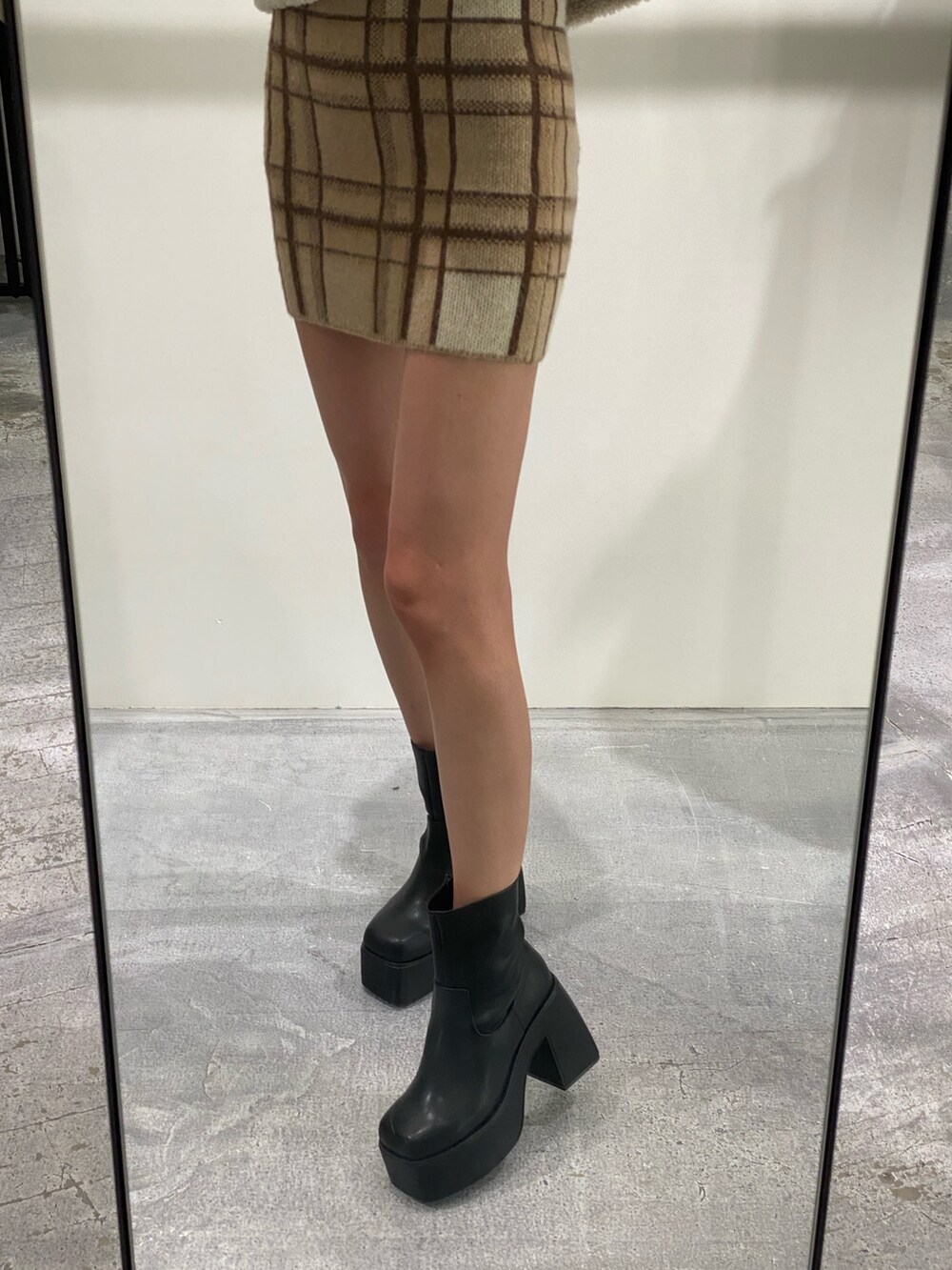 ベージュ系のニット/セーター、ベージュ系のスカート、ブラック系のブーツを着用したレディースの冬コーディネートの6枚目の写真