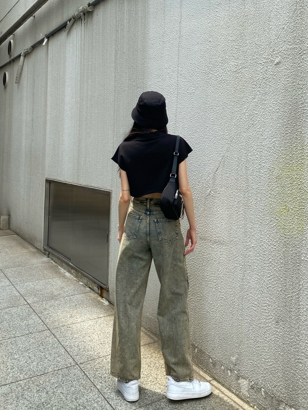 ブラック系のTシャツ/カットソー、ブラック系のハンドバッグ、ベージュ系のデニムパンツを着用したレディースの夏コーディネートの3枚目の写真