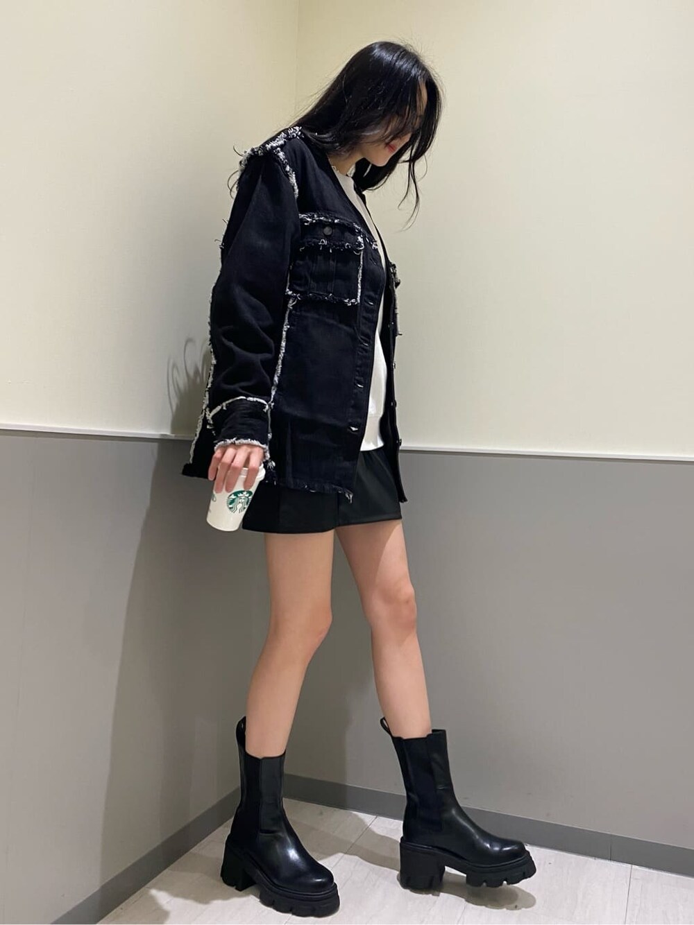 ブラック系のブーツ、ブラック系のデニムジャケット、ホワイト系のスウェットを着用したレディースの秋コーディネートの5枚目の写真