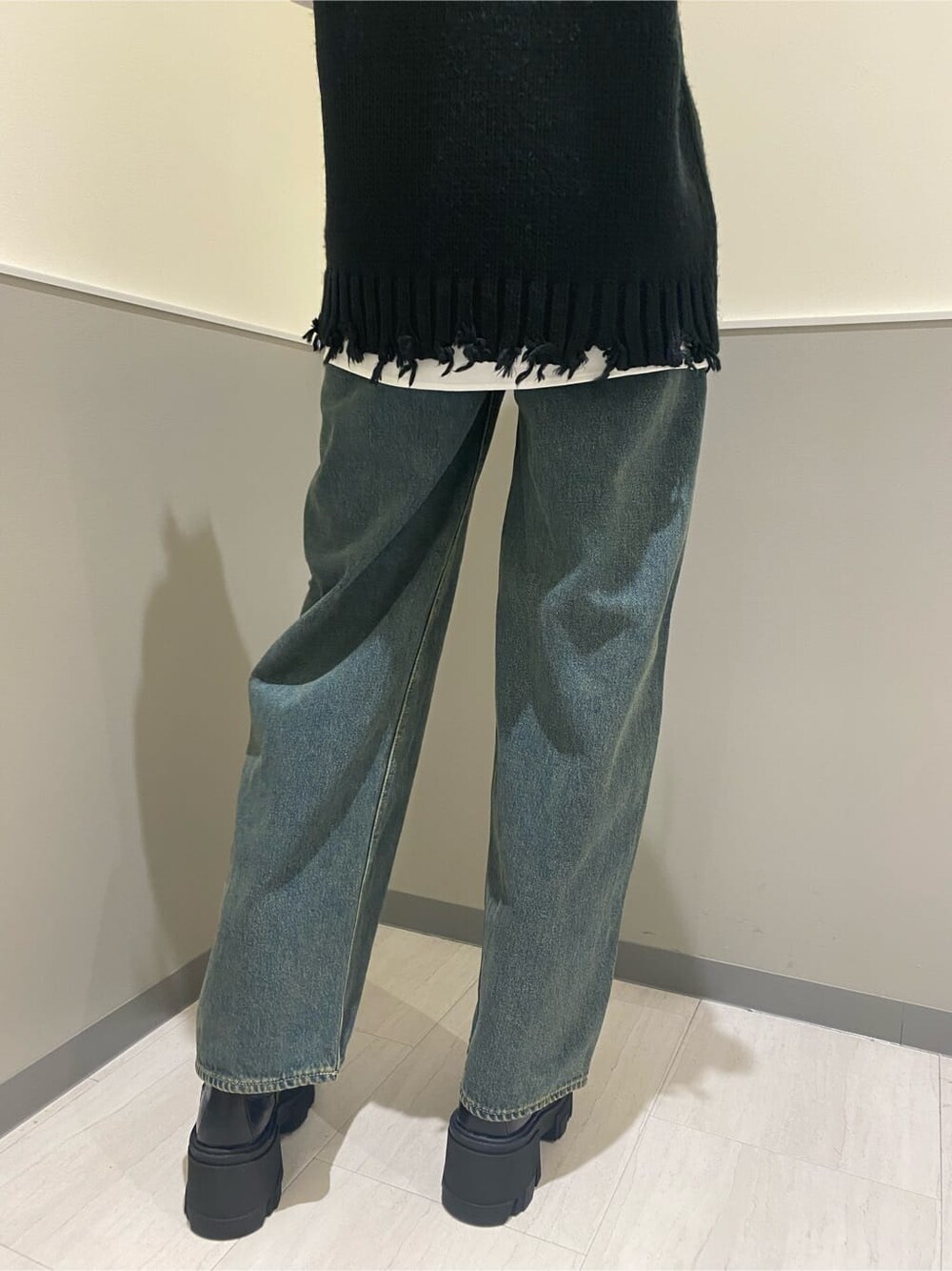 ブラック系のブーツ、ホワイト系のシャツ/ブラウス、ブルー系のデニムパンツを着用したレディースの秋コーディネートの6枚目の写真