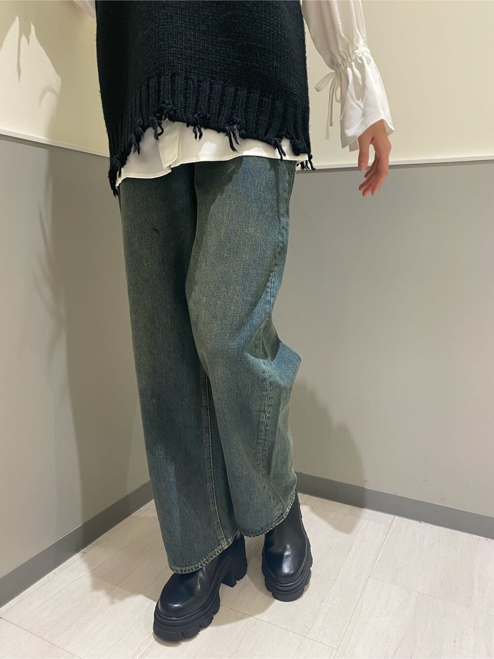 ブラック系のブーツ、ホワイト系のシャツ/ブラウス、ブルー系のデニムパンツを着用したレディースの秋コーディネートの7枚目の写真
